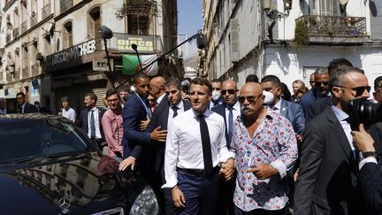 En visite à Oran (Algérie), Emmanuel Macron a visité la boutique du label de raï Disco Maghreb, avec son patron&nbsp;Boualem Benhaoua. (Ludovic MARIN / AFP)