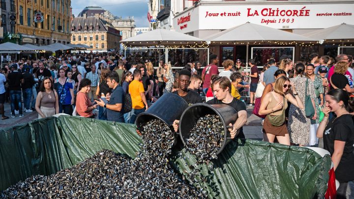 Des bassines de moules déjà consommées, (le plat local) déversées dans une grande poubelle, au coeur de la Braderie de Lille ce dimanche 3 septembre 2023. Les visiteurs chinent, mangent, se retrouvent en famille. C'est l'événement majeur de cette rentrée dans les Hauts de France. (FRANCOIS LO PRESTI / AFP)