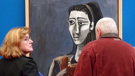 Deux visiteurs regardent, le 06 novembre 2003 à la pinacothèque de Paris, "Jacqueline assise dans un fauteuil", une huile sur toile&nbsp;de Picasso datant de 1962 (THOMAS COEX / AFP)