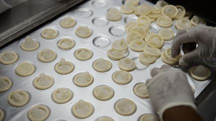 Un ouvrier fabrique des préservatifs dans l'usine de Natex à Xapuri, au Brésil, le 7 octobre 2014. (YASUYOSHI CHIBA / AFP)