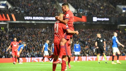 Bruno Guimaraes et Islam Slimani fêtent le deuxième but marqué par l'Algérien face aux Glasgow Rangers, le 16 septembre 2021. (ANDY BUCHANAN / AFP)