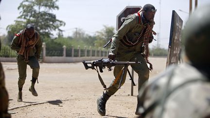 Des soldats maliens courrent pour se mettre &agrave; couvert &agrave; Gao, le 21 f&eacute;vrier 2013. (FREDERIC LAFARGUE / AFP)