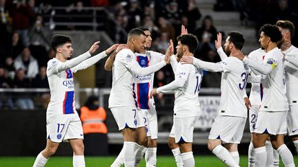 Les joueurs du Paris Saint-Germain se congratulent après un but de Kylian Mbappé lors de Angers-PSG, au stade Raymond-Kopa, le 21 avril 2023. (DAMIEN MEYER / AFP)