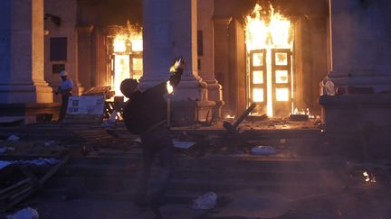 Un manifestant envoie un explosfi artisanal en direction de la Maison des syndicats d'Odessa (Ukraine), vendredi 2 mai. (STRINGER / REUTERS)