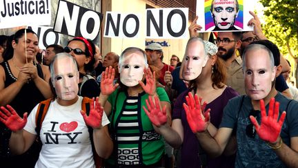 Des manifestants portent des masques &agrave; l'effigie de Vladimir Poutine et d&eacute;noncent l'homophobie en Russie, le 23 ao&ucirc;t 2013, devant l'ambassade russe de Madrid (Espagne). (GERARD JULIEN / AFP)