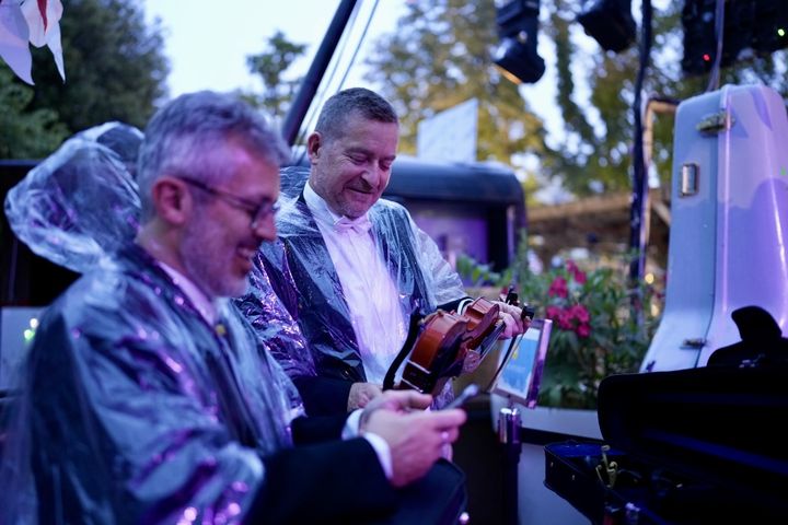 Des musiciens de l'Orchestre national de France vêtus d'un poncho anti-pluie lors de la cérémonie d'ouverture des Jeux olympiques, le 26 juillet 2024. (CHRISTOPHE ABRAMOVITZ / RADIO FRANCE)