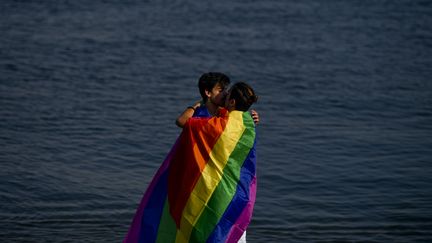 Deux hommes s'embrassent près de la rivière Tage à Lisbonne (Portugal), le 17 juin 2017. (PATRICIA DE MELO MOREIRA / AFP)