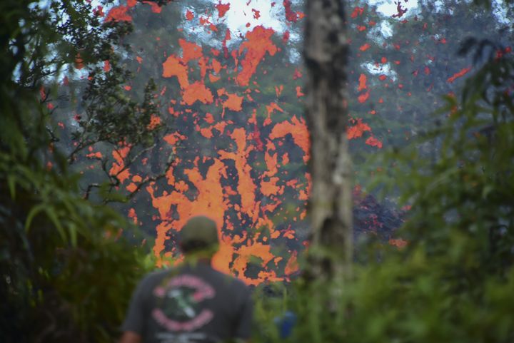 Un homme observe de la lave s'échapper d'une fissure volcanique à Leilani Estates, sur l'île d'Hawaï (Etats-Unis), le 4 mai 2018.&nbsp; (FREDERIC J. BROWN / AFP)