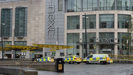 Des voitures de police devant le centre commercial où plusieurs personnes ont été poignardées à Manchester (Royaume-Uni), le 11 octobre 2019. (PETER POWELL / REUTERS)