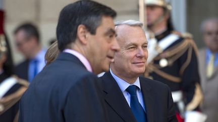 Fran&ccedil;ois Fillon et Jean-Marc Ayrault, lors de la passation de pouvoirs &agrave; Matignon, le 16 mai 2012. (FRED DUFOUR / AFP)