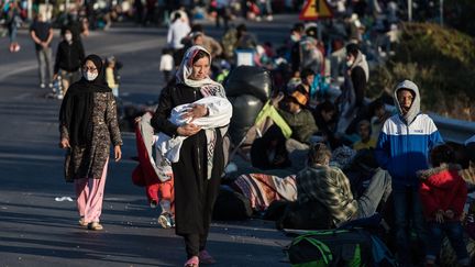 Des demandeurs d'asile rassemblés sur le bord d'une route, sans abri, après l'incendie qui a ravagé le camp de Moria, sur l'île grecque de Lesbos. (KOSTIS NTANTAMIS / SPUTNIK)