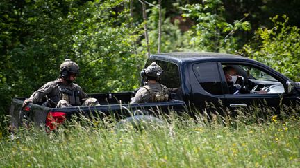 Des membres du GIGN sont assis à l'arrière d'un pick-up lors de la recherche d'un homme qui a abattu deux personnes dans une scierie près du village de Plantiers dans les Cévennes, le 12 mai 2021. (CLEMENT MAHOUDEAU / AFP)