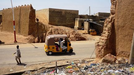 Cette partie du mur de la ville de Kano a été détruite pour faire place à la rue. Ici comme ailleurs, la démolition et la dégradation des pans de murs mettent en danger ces anciens vestiges transformés à certains endroits en dépotoirs à ciel ouvert. Les rares travaux de fortification ne suffisent pas à preserver cet héritage historique. La Commission nationale des musées et des monuments avait demandé, en 2007, le classement des remparts de Kano au Patrimoine mondial de l'Unesco. Plus de dix ans plus tard, les dommages incessants sur les fortifications risquent de compromettre encore plus une éventuelle reconnaissance de ce site. (AMINU ABUBAKAR / AFP)