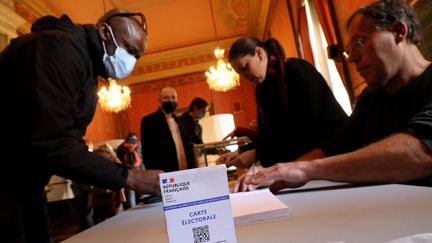 Deux assesseurs et un votant à Marseille, lors du premier tour de l'élection présidentielle 2022. (NICOLAS VALLAURI / MAXPPP)