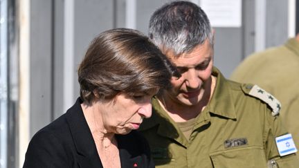 La ministre française des Affaires étrangères, Catherine Colonna avec le porte-parole de l'armée israélienne le 17 décembre 2023, sur la base militaire de Shura, devant le centre où les victimes des massacres du 7 octobre sont identifiées. (ALBERTO PIZZOLI / AFP)