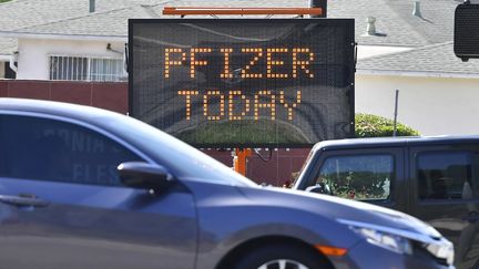 Des automobilistes passent devant un panneau annonçant des doses du vaccin contre le Covid-19 de Pfizer disponible, à Cal State Los Angeles en Californie, le 3 mai 2021. (FREDERIC J. BROWN / AFP)