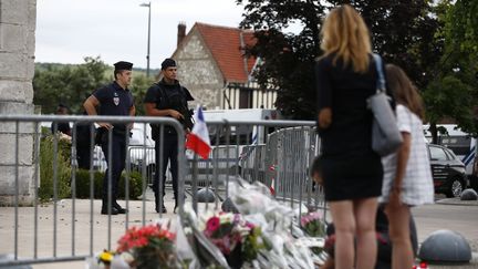 Des personnes se recueillent&nbsp;devant l'église à Saint-Etienne-du-Rouvray (Seine-Maritime), le 27 juillet 2016. (IAN LANGSDON / EPA)