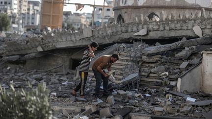 Des habitants de la bande de Gaza près de la mosquée détruite Sheikh Zeyed Al Nahyan, le 4 novembre 2023. (ALI JADALLAH / ANADOLU / AFP)