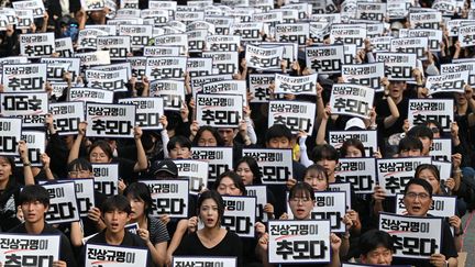 Un rassemblement le 4 septembre 2023 en hommage à une enseignante qui s'est suicidée en juillet. Les manifestants brandissent des pancartes indiquant "Révéler la vérité est le moyen de rendre hommage" et exigent la protection des droits des enseignants devant l'Assemblée nationale à Séoul. (JUNG YEON-JE / AFP)