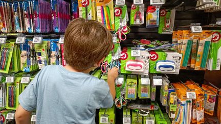 Un enfant observe les fournitures scolaires, le 10 juillet 2023, dans une enseigne de Paris. (RICCARDO MILANI / HANS LUCAS / AFP)