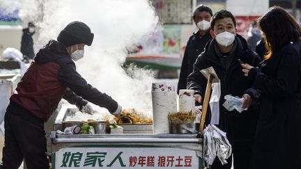 Des passants dans les rues d'Urumqi (Chine), le 1er décembre 2022. (CNS / AFP)