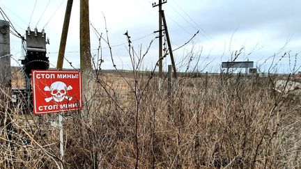 Un panneau d'avertissement de terrains minés sur ligne de front dans les faubourgs de Marioupol, à quelques kilomètres de la partie du Donbass contrôlée par les séparatistes pro-russes. (BENJAMIN ILLY / RADIO FRANCE)