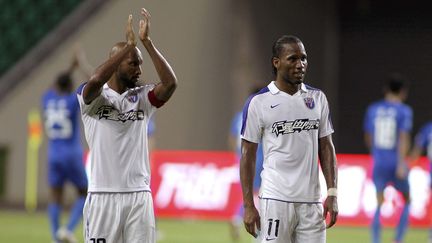 Nicolas Anelka et Didier Drogba, joueurs du Shanghai Shenhua,&nbsp;saluent le public, le 22 juillet 2012, &agrave; Guangzhou (Chine). ((AP / SIPA))