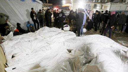 Des corps de victimes de la frappe survenue dans la zone du camp de réfugiés d'al-Maghazi, dans le centre de la bande de Gaza, le 24 décembre 2023. (ASHRAF AMRA / ANADOLU / AFP)