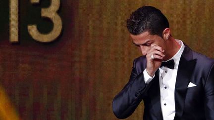 Le Portugais Cristiano Ronaldo essuie une larme en recevant le Ballon d'or 2013 &agrave; Z&uuml;rich (Suisse), le 13 janvier 2014. (RUBEN SPRICH / REUTERS)