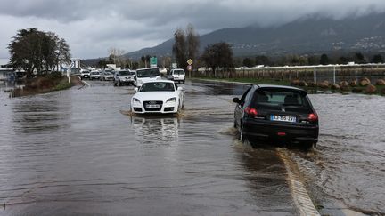 Des voitures tentent de circuler sur une route près de l'aéroport d'Ajaccio, malgré les inondations qui frappent la ville, le 21 décembre 2019. (PASCAL POCHARD-CASABIANCA / AFP)