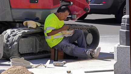 Un ouvrier se restaure sur un chantier, le 20 juillet 2022, à Madrid (Espagne). (PAUL WHITE / AP / SIPA)