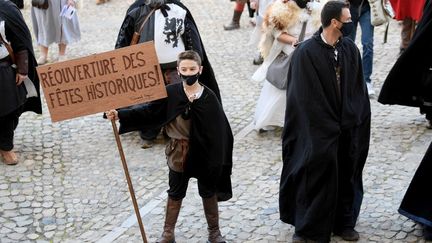 Un garçon portant un costume d'époque lors d'une manifestation de personnes travaillant dans le secteur de la reconstitution historique, à Avignon (Vaucluse), le 27 mars 2021.
 (NICOLAS TUCAT / AFP)