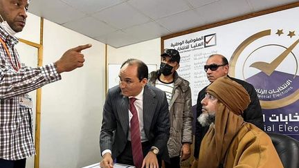 Une photo publiée par la page Facebook de la Haute Commission électorale nationale (HNEC), le 14 novembre 2021, montre Seif al-Islam Kadhafi (assis), fils du dictateur libyen assassiné, s'inscrivant pour participer à la présidentielle du 24&nbsp;décembre 2021, dans la ville de Sebha,&nbsp;au sud de la Libye.&nbsp; (STRINGER / LIBYAN HIGH NATIONAL ELECTORAL COMMISSION)