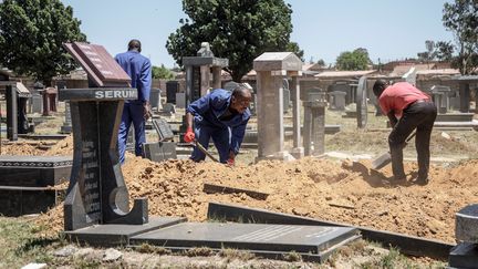 Dans le cimetière de Roodeport, à Johannesburg, le 22 novembre 2018, des fossoyeurs creusent d'anciennes tombes pour faire de la place aux nouveaux cercueils arrivant chaque jour. (GIANLUIGI GUERCIA / AFP)