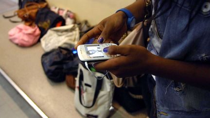 Une élève utilisant un téléphone portable dans un établissement scolaire, lors d'une épreuve du baccalauréat.&nbsp; (DURAND FLORENCE / SIPA)