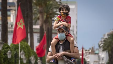 Un père avec son fils sur les épaules dans le centre de Rabat, la capitale du Maroc, le 16 juin 2020. (FADEL SENNA / AFP)