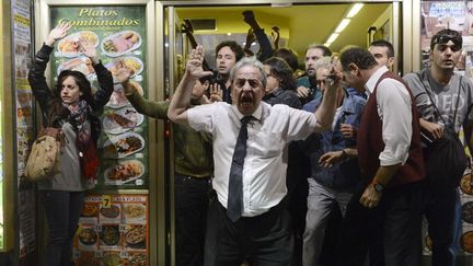 Des manifestants se r&eacute;fugient dans un restaurant alors que des heurts &eacute;clatent entre des "indign&eacute;s" et les forces de l'ordre, &agrave; Madrid (Espagne), le 25 septembre 2012.&nbsp; (PIERRE-PHILIPPE MARCOU / AFP)