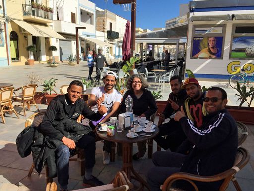 Sadika Keskes (au centre) discute avec de jeunes Tunisiens à Lampedusa. (Clara Puente)