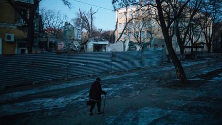 Une femme passe devant des bâtiments résidentiels détruits à Kramatorsk, en Ukraine, le 23 février 2023. (GIAN MARCO BENEDETTO / ANADOLU AGENCY / VIA AFP)