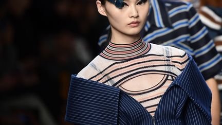 Chez Fendi, Karl Lagerfeld offrre "un tourbillon de couleurs et de saveurs caribéennes" avec une garde-robe riche en figures géométriques et en damiers présentée sur une musique jungle électro par des mannequins stars comme Gigi Hadid, Kendall Jenner et Kaia Gerber, 16 ans, fille de Cindy Crawford. Il y a aussi l'idée de légèreté dans ce vestiaire où les vêtements style "filet de pêche" en Nylon ou organza côtoient les franges qui rappellent d'exotiques branches de palmier. Aucun signe de tristesse, ni d'austérité dans la collection qui arrive trois mois après la mort à 80 ans de Carla Fendi, l'une des cinq sœurs à l'origine du développement de la griffe romaine. Sur le podium, les jupes légères et les manteaux sont bleu océan, vert écume de mer ou rose corail ; et les chemises en coton, à rayures ultra-fines, sont serrées haut sur la taille. Au milieu de ces impressions de vacances balnéaires, Lagarfeld peut glisser un trench denim ou une robe de cuir marron, style pionnier à la conquête de l'ouest. Le show a aussi été l'occasion pour la marque de révéler ses derniers accessoires -- secteur qui reste l'une de ses sources majeures de revenus -- avec un nouveau sac en cuir Mon Trésor, agrémenté de perles métalliques et un élégant sac en trapèze Runaway en mailles transparentes avec anses en rotin. 
 (Miguel MEDINA / AFP)