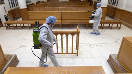 Des agents de santé désinfectent une salle de tribunal à L'Ariana, près de Tunis, le 12 mars 2020. (FETHI BELAID / AFP)