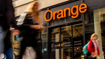 Des piétons passent devant une boutique de l'opérateur téléphonique Orange à Lille (Nord). (PHILIPPE HUGUEN / AFP)