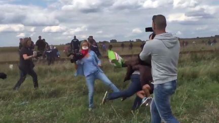 Une journaliste de la cha&icirc;ne hongroise N1TV fait un croche-pied &agrave; un migrant pr&egrave;s de la fronti&egrave;re serbe, mardi 8 septembre 2015. (STEPHAN RICHTER / TWITTER)