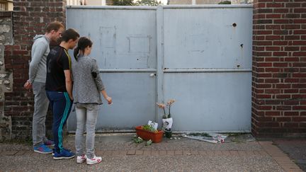 Autre lieu d'hommage : le presbytère où vivait le prêtre Jacques Hamel. Quelques fleurs, quelques mots griffonnés sur des feuilles blanches ont été posés devant la porte. (MATTHIEU ALEXANDRE / AFP)