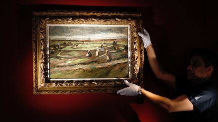 Le tableau de Van Gogh, "Raccommodeuses de filets dans les dunes", est présenté à la vente à Paris, le 28 mars 2018. (PATRICK KOVARIK / AFP)