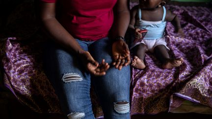 Une femme et son enfant se reposent le 26 juin 2019 à Benin City, dans l'un des centres d'hébergement de la Société pour l'autonomisation des jeunes (SEYP), une organisation qui réhabilite et réintègre les femmes revenant de Libye portant souvent des enfants en bas âge, résultat de viol. (FATI ABUBAKAR / AFP)