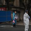 Un homme tient un portrait d'une proche défunte devant un cimetière de Wuhan, le 31 mars 2020, peu après que les habitants ont commencé à récupérer les cendres des personnes mortes lors de la période de confinement. (HECTOR RETAMAL / AFP)