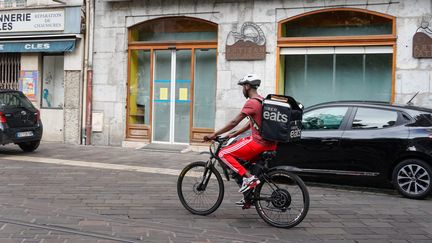 Un livreur Uber à vélo dans les rues de Grenoble (Isère), le 26 août 2023. (LAURE BOYER / AFP)