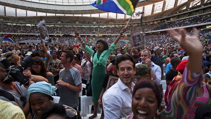 Une femme agite un drapeau sud-africain lors d'un hommage rendu &agrave; Nelson Mandela dans le stade du Cap (Afrique du sud), le 11 d&eacute;cembre 2013. (REUTERS)