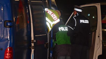 Des policiers allemands fouillent un véhicule dans le cadre d'une opération anti-terroriste à Berlin (Allemagne), le 26 novembre 2015. (JOHN MACDOUGALL / AFP)